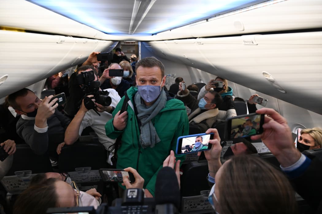 Russian opposition leader Alexei Navalny walks to take his seat in a Pobeda airlines plane heading to Moscow before take-off from Berlin Brandenburg Airport (BER) in Schoenefeld, southeast of Berlin, on 17 January, 2021.