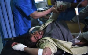 A wounded Afghan man receives treatments at a hospital after a car bomb attack in Kabul.