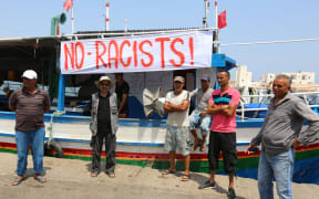 Tunisian fishermen say Muslims and Africans are dying and blocked the vessel from docking.