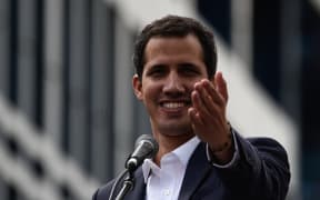 Venezuela's National Assembly head Juan Guaido speaks to the crowd during a mass opposition rally against leader Nicolas Maduro in which he declared himself the country's "acting president", on the anniversary of a 1958 uprising that overthrew a military dictatorship, in Caracas on January 23, 2019.