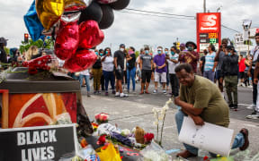 A man prays in front of a makeshift memorial in honor of George Floyd who died in custody on May 26, 2020 in Minneapolis, Minnesota.