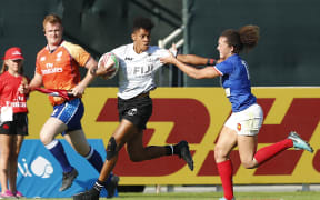 Fiji's Naina Baleca fends off a France defender in Dubai.
