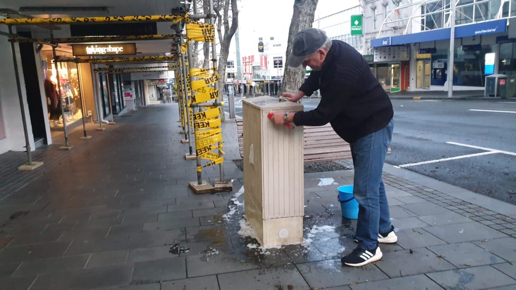 New Plymouth man Paul taking advantage of the quiet to scrub down the utilities box outside his apartment.
