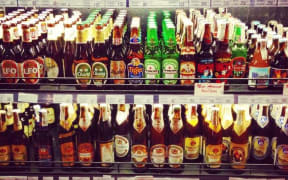 A supermarket shelf stocked with bottles of imported beer.