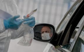 Biologists take samples by appointment from people with symptoms of Covid-19 without having to get out of their vehicles on April 6, 2020 in Saint-Nazaire, France.
