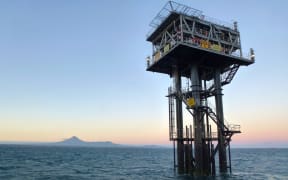 Southern Star Oil rig platform at sunset with  Mt Taranaki in the background