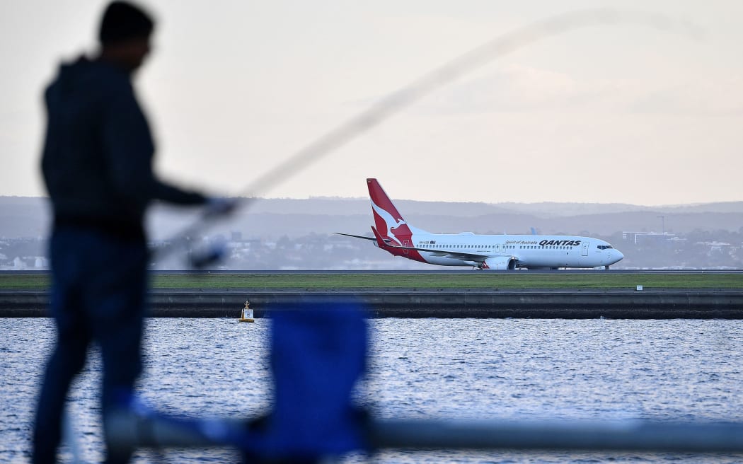 A Qantas Airline plane lands on Sydney International Airport in Sydney on March 27, 2020.