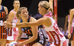 The Tactix Anna Thompson passing the ball for under pressure from Adelaide defender Renae Hallinan.