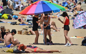 People enjoy the warm weather on Melbourne's St Kilda Beach on November 3, 2020, as Australia's Victoria state records its fourth straight day of zero transmissions of the COVID-19 coronavirus after battling a second wave of infections.