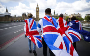 People walk over Westminster Bridge wrapped in Union flags.