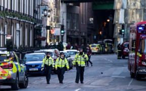 Police officers and emergency response vehicles are seen on the street outside Borough Market.