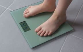 Child with bare feet on a bathroom scale of glass