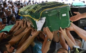 People carry a coffin during a funeral for victims of the attack.