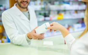 Experienced pharmacist counseling female customer in modern farmacy