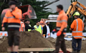 Representatives of the Muslim community and workers prepare grave sites for victims in Christchurch.