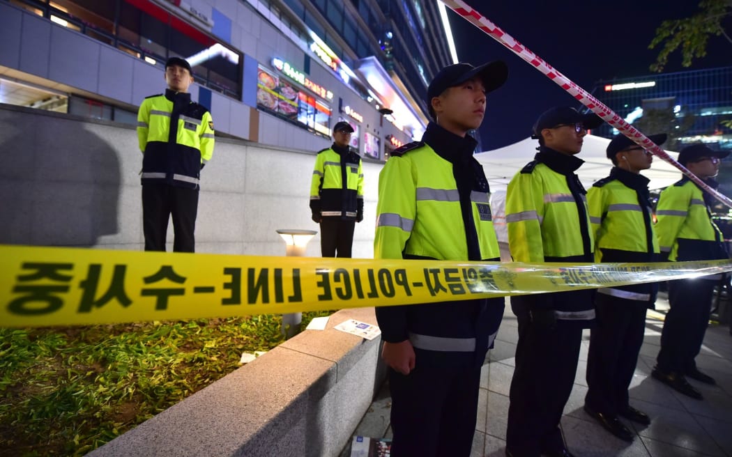 Police stand guard near the broken ventilation grate in Seongnam City, south of Seoul, on 17 October.