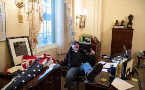 In this file photo taken on 6 January 2021, Richard Barnett, a supporter of US President Donald Trump sits inside the office of US Speaker of the House Nancy Pelosi as he protests inside the US Capitol in Washington, DC.