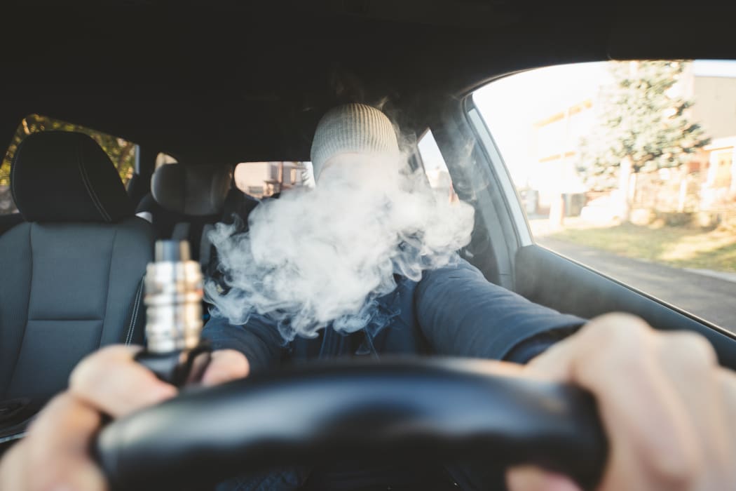 Vaping flavored e-liquid from an electronic cigarette in a car