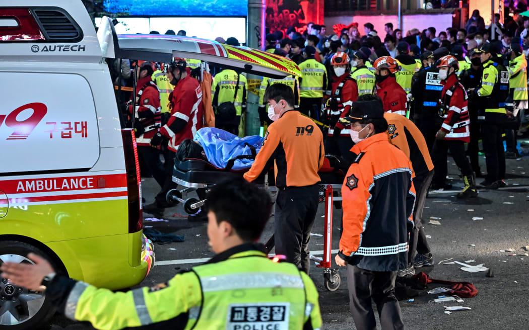 Paramedics tend to a victim who appears to be suffering from cardiac arrest on October 30, 2022 in Itaewon, a popular nightlife district in Seoul. In the city's Itaewon district to celebrate Halloween, local officials said. (Photo credit: JUNG YEON-JE / AFP)