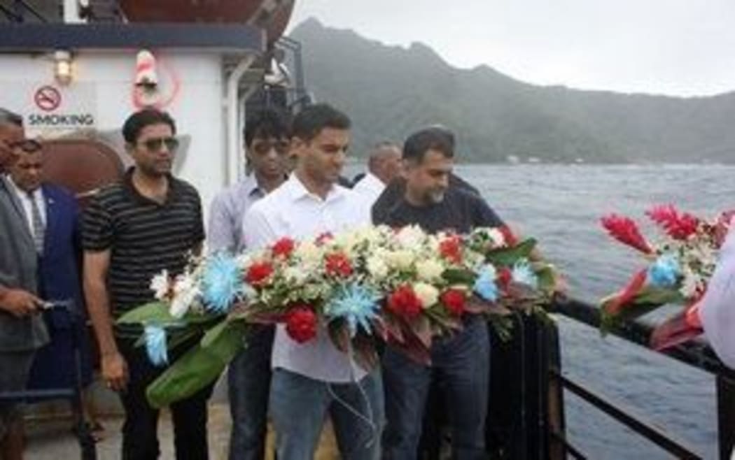 Cyrus Suleman, brother of 17-year-old pilot Haris Suleman about to toss a wreath at sea, in honor of his brother and still missing father, Babar Suleman.
