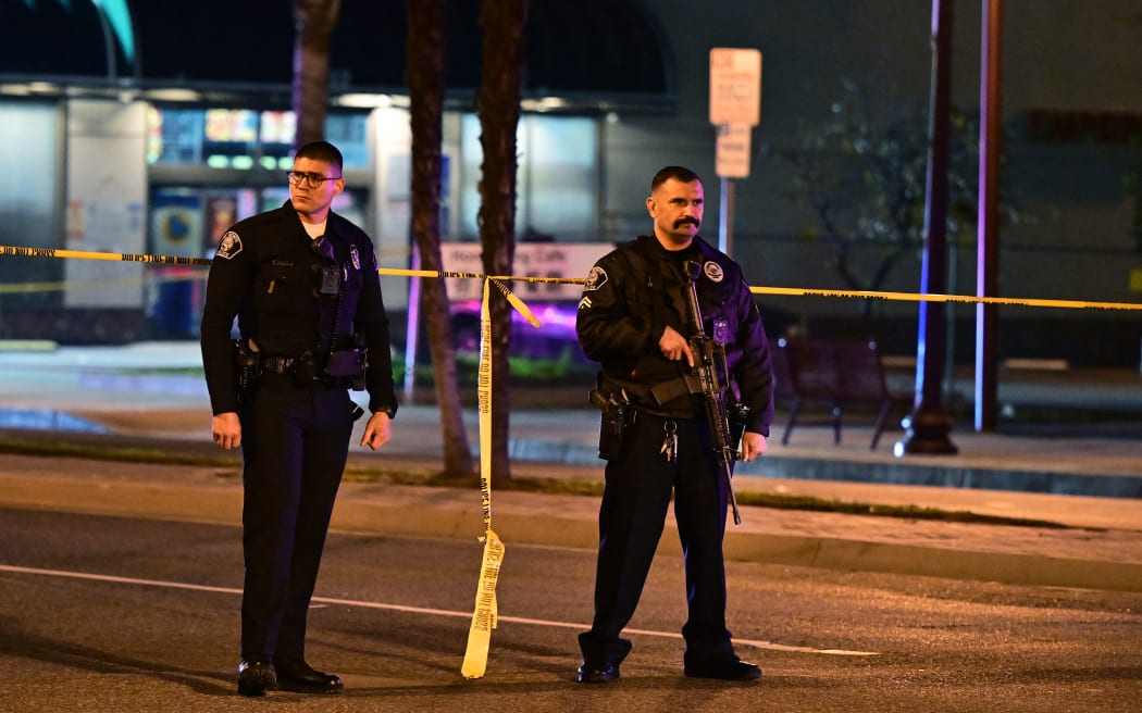 Police stand guard at the scene along Garvey Avenue in Monterey Park, California, after responding to reports of multiple people shot.