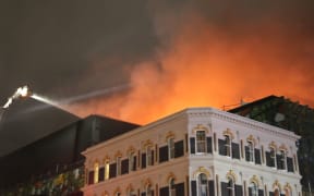 The smoke billowing from the rooftop of the SkyCity convention centre is lit up by the flames into the night. (22 October)