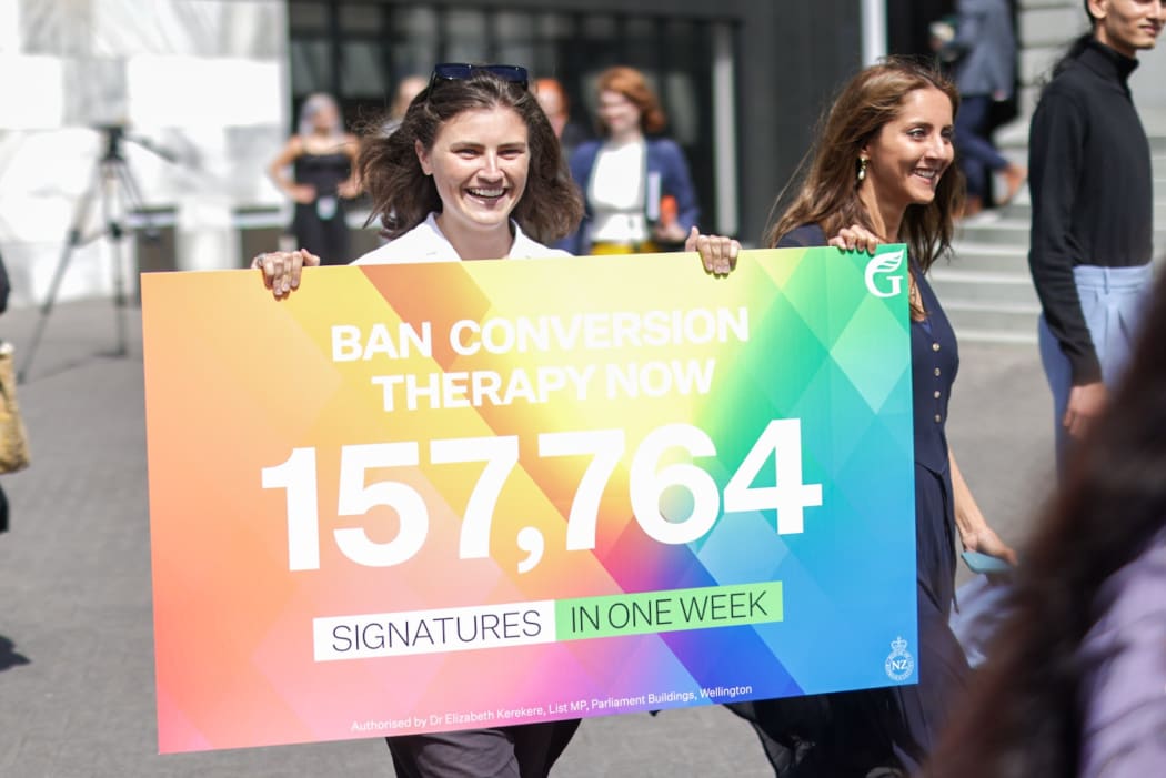Chlöe Swarbrick holds up a placard showing the number of signatures in support of a ban on conversion therapy.