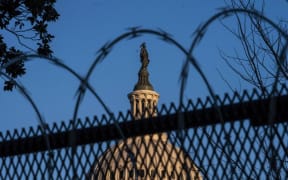 The exterior of the U.S. Capitol building is seen through barbed wire fencing at sunrise on February 8, 2021 in Washington, DC.