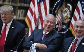 Stephen A. Schwarzman (C), CEO of the Blackstone Group, and Chris Liddell (R), White House Director of Strategic Initiatives, and US President Donald Trump (L) and others in the  White House campus April 11, 2017 in Washington, DC.