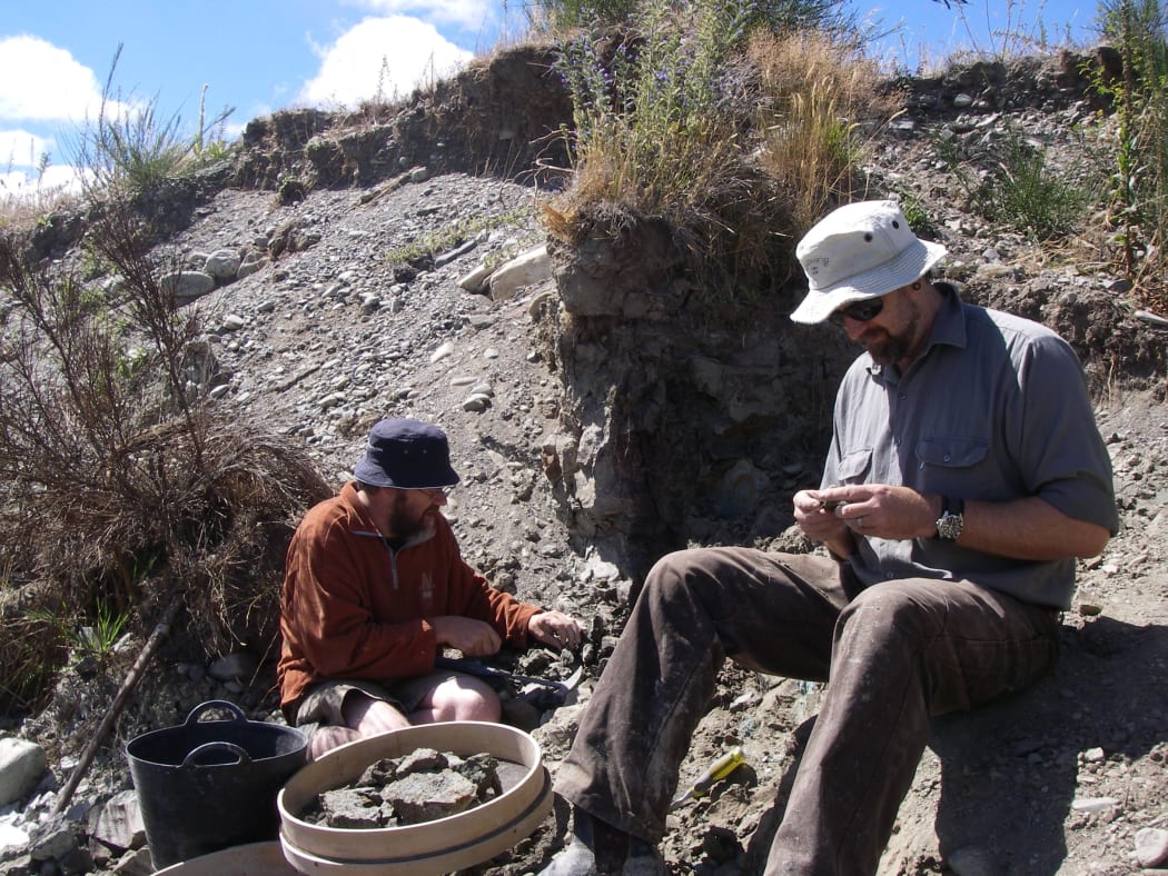 Paul Scofield and Steve Salisbury sort rocks at the St Bathans fossil site.