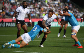 Fiji's centre Jale Vatubua (C) is tackled by Juan Manuel Cat (L) and flanker Santiago Civetta (R).