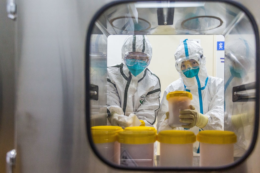 Staff members receive the novel coronavirus strain transported from Zhejiang Provincial Center for Disease Control and Prevention, at a laboratory of Chinese Center for Disease Control and Preventio on Feb. 25, 2020.