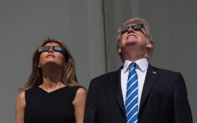 US President Donald Trump and First Lady Melania Trump look up at the partial solar eclipse from the balcony of the White House in Washington, DC, on August 21, 2017.