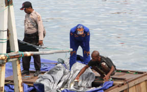 Indonesian police secure a vessel suspected of illegal fishing in West Papua waters.