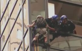 A man climbs Trump Tower using what appeared to be suction cups.