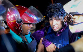 Bangladeshi police officers help a colleague injured during an attack on an upscale Dhaka restaurant.