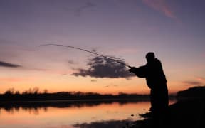 A file photo shows a man casting his line into a river.