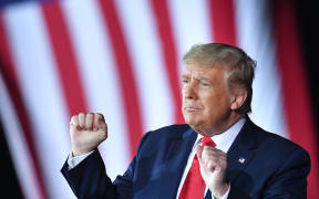 US President Donald Trump pumps his fists during a campaign rally at MBS International Airport in Freeland, Michigan on September 10, 2020.