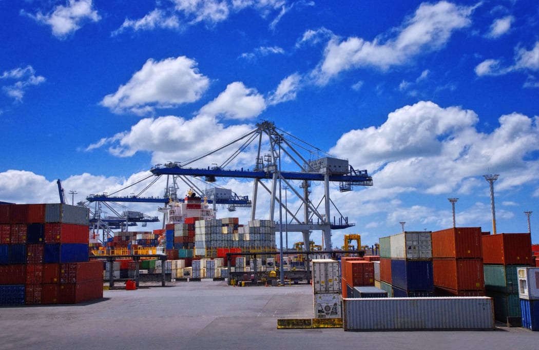 View of colorful containers and cargo cranes in a port.