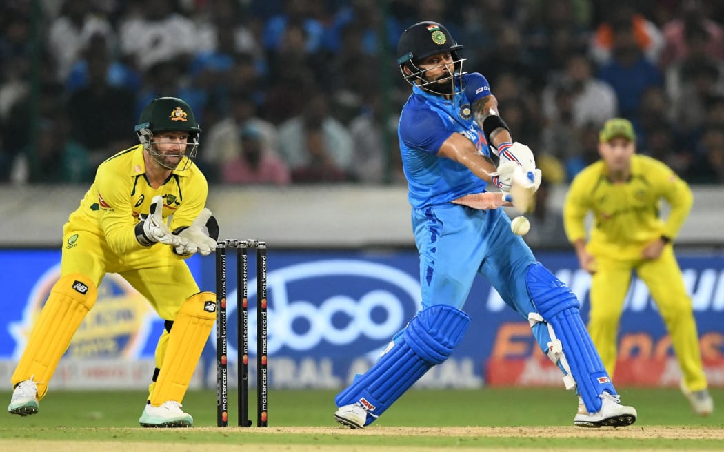 India's Virat Kohli plays a shot as Australia's wicketkeeper Matthew Wade (L) watches during the third Twenty20 international cricket match between India and Australia at the Rajiv Gandhi International Cricket Stadium in Hyderabad on September 25, 2022. (Photo by NOAH SEELAM / AFP) / ----IMAGE RESTRICTED TO EDITORIAL USE - STRICTLY NO COMMERCIAL USE-----