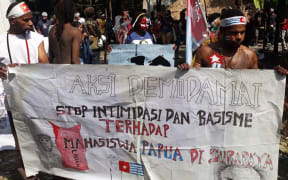 Papuan demonstrators holding a banner that says 'stop intimidation and racism towards students of Papua'.