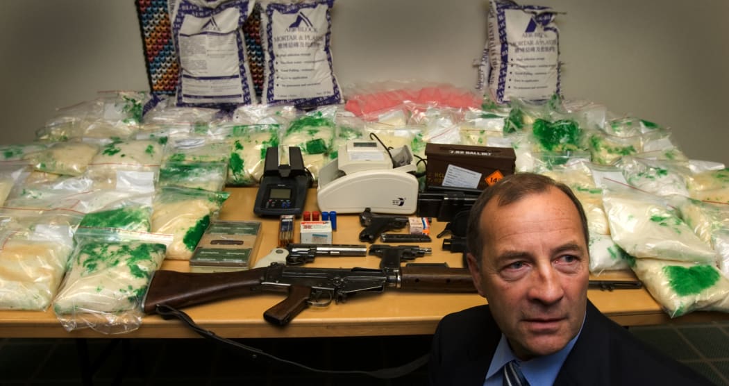 Detective Inspector Bruce Good with New Zealand's largest drug haul, $95million worth of Methamphetimine which was intercepted as it was imported into the Country. A raid on a house found the arms and ammunition on the table. 25 May 2006.