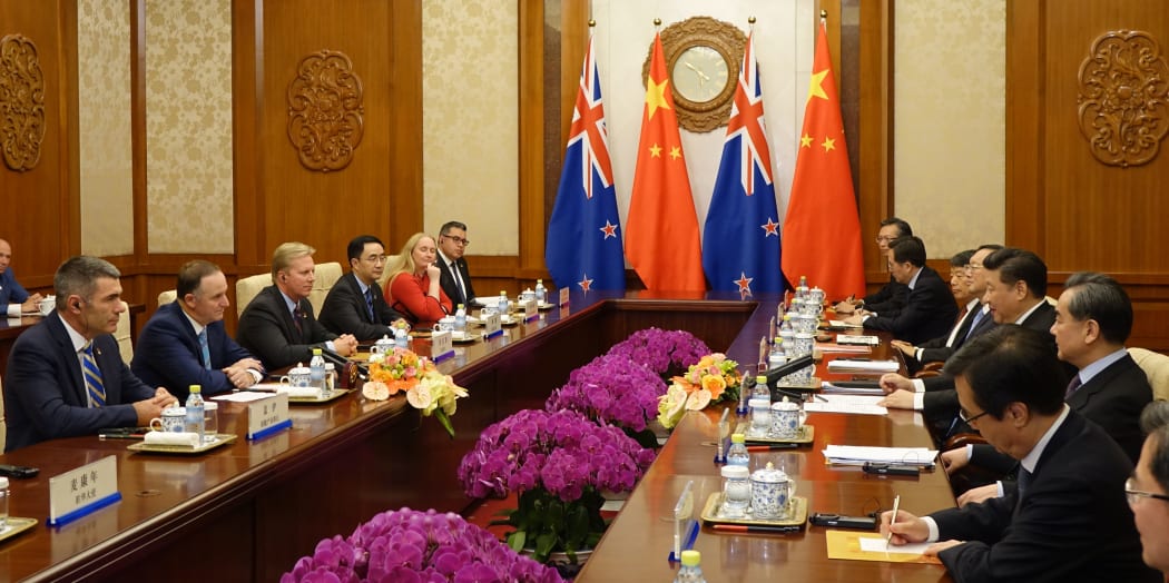 John Key and President Xi hold talks in the wood-pannelled Diaoyutai State Guesthouse in Beijing. The flags of China and New Zealand hang above the two parties seated at long tables opposite each other