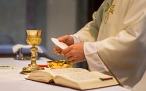 Bread and wine are used to celebrate the Eucharist during Roman Catholic masses. Here, a priest holds a wedding ceremony mass.