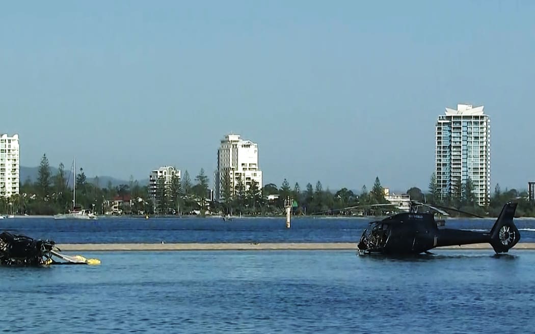 In this photo taken and released on January 3, 2023, two helicopters rest in the water after they collided mid-air on the Gold Coast on January 2, killing four people.