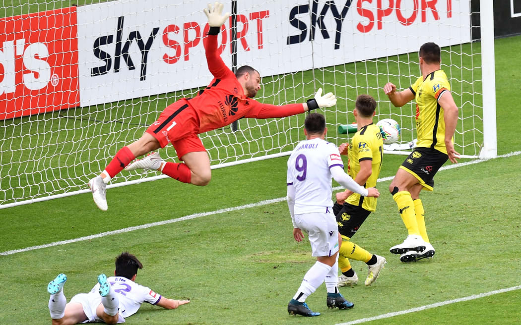 Phoenix's keeper Stefan Marinovic (L) makes a save during the A-League - Phoenix v Perth Glory football match at Westpac Stadium in Wellington.