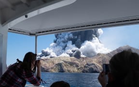 This handout photograph courtesy of Michael Schade shows the volcano on New Zealand's White Island spewing steam and ash moments after it erupted on December 9, 2019.