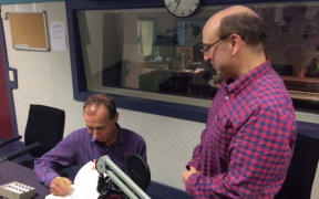 David Farrar has his copy of "Dirty Politics" signed by author Nicky Hager in Radio New Zealand's Morning Report studio.