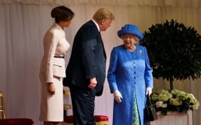 US President Donald Trump speaks with Queen Elizabeth II as US First Lady Melania Trump looks on at Windsor Castle.