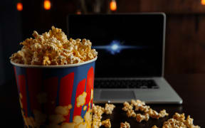Watching movies on laptop with popcorn.